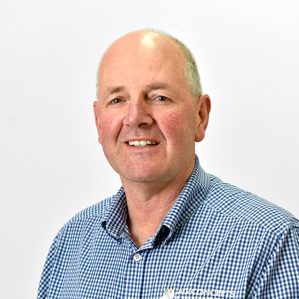 A portrait photo of Mecardo team member Rob, in front of a white background wearing a blue and white checked shirt